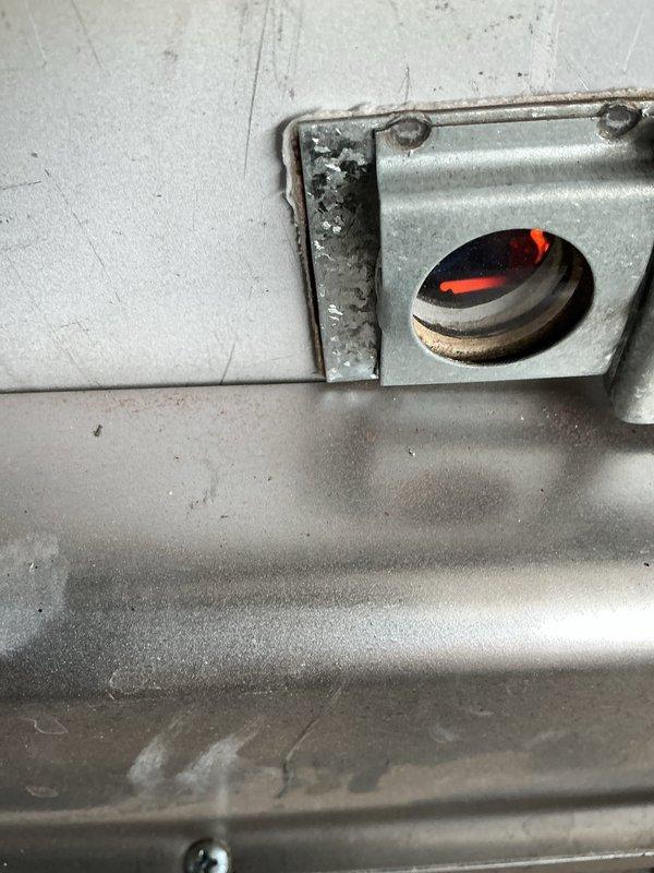 Completed routine heating maintenance on residential gas-fired water heater system. Performed visual inspection of all internal components, burner assembly, and heat exchanger. Verified proper flame characteristics and combustion through observation port, confirming normal orange-red flame pattern and burner operation. Inspected condensate collection tray, gas valve assembly, venting system, and all associated piping connections for signs of leaks or deterioration. All components found to be functioning within normal operating parameters at time of service.