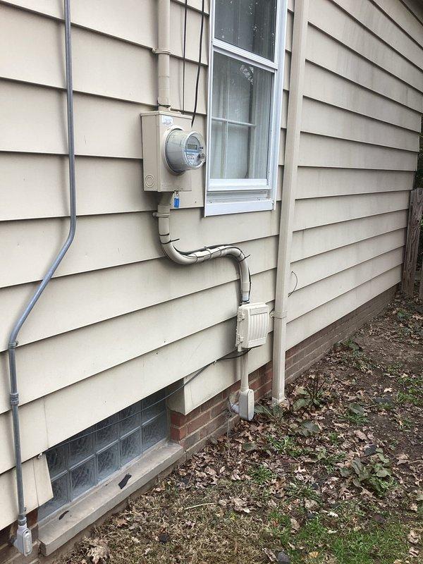 Conducted comprehensive electrical panel assessment for estimate purposes. Documented existing 200-amp main service panel installation, photographed internal breaker configuration showing dual-row circuit breaker arrangement with associated branch circuit wiring, and evaluated exterior meter base connection with PVC conduit routing along foundation. Assessed panel capacity, wiring conditions, and service entrance components to provide accurate replacement quotation.