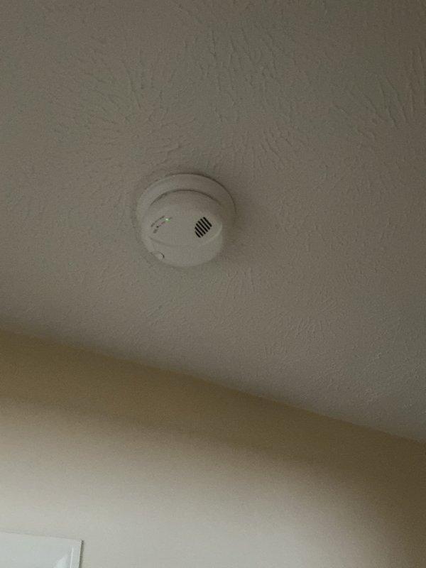 Installed new smoke and carbon monoxide detectors on residential ceiling. Mounted units securely to textured ceiling surface, verified proper operation of indicator lights, and confirmed devices were functioning correctly per manufacturer specifications.