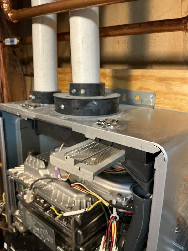 # HVAC Heating System Maintenance Completed

Performed comprehensive heating system maintenance on a Rinnai tankless water heater and associated HVAC equipment. Inspected all copper plumbing connections, pressure gauges, shut-off valves, and flexible metallic hoses for proper operation and potential leaks. Verified digital display reading of 104°F and confirmed unit functionality. Examined control boards, circuit boards with heat sinks, and all electrical wiring connections including red, yellow, black, and white conductor runs. Inspected PVC vent pipes, rubber coupling fittings, and copper refrigerant lines with brazed joints for secure installation and proper venting. All components found to be operating within normal parameters with no issues requiring immediate attention.