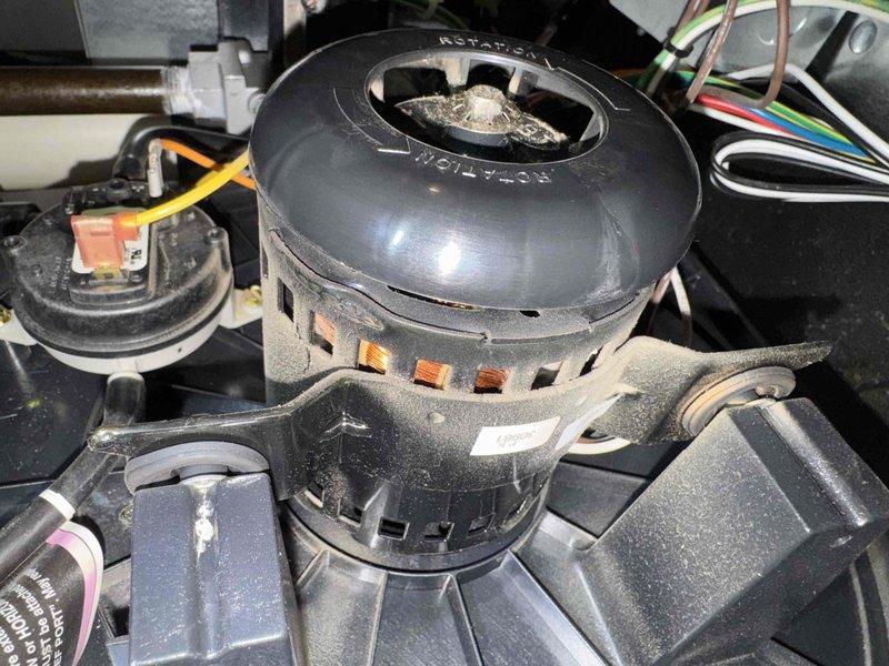 Performed comprehensive heating maintenance on HVAC system, including thorough inspection of blower motor assembly and electrical connections. All wiring, including ground connections and multi-colored conductor leads, were examined and found to be secure with no signs of damage or overheating. Motor housing and surrounding components showed normal operational wear with dust accumulation typical for the unit's service period. Verified proper motor rotation marking and confirmed all mounting brackets and hardware were properly secured. Inspected air handler interior, circular access panel, and ductwork for structural integrity and proper sealing. System components including auxiliary electrical devices and terminal connections were evaluated and determined to be functioning within normal parameters.