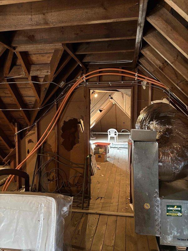 Completed comprehensive HVAC system installation including steam-to-hot water boiler conversion with new piping infrastructure, Unico air handler with ductwork installed in attic space, hot water heating loop with panel radiators, and mini split system. All mechanical systems commissioned and operational with copper supply lines properly connected throughout residence.