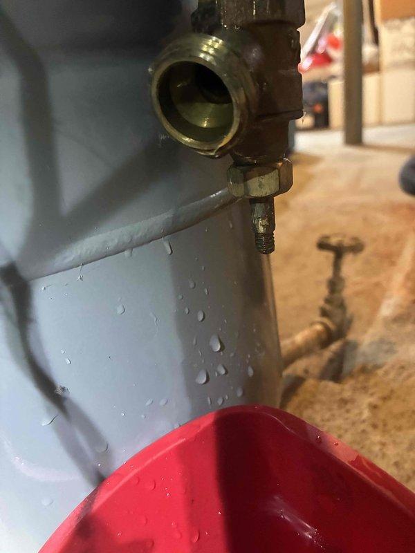 Performed routine boiler maintenance including inspection of pressure reducing valve (Watts Model 1156C, 10-25 PSI range) and associated plumbing connections. Identified active water seepage from brass valve assembly on expansion tank, placed temporary catch basin to contain dripping, and documented conditions for follow-up repair recommendations.