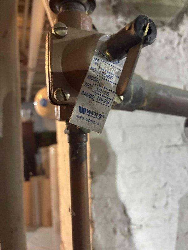 Performed routine boiler maintenance including inspection of pressure reducing valve (Watts Model 1156C, 10-25 PSI range) and associated plumbing connections. Identified active water seepage from brass valve assembly on expansion tank, placed temporary catch basin to contain dripping, and documented conditions for follow-up repair recommendations.