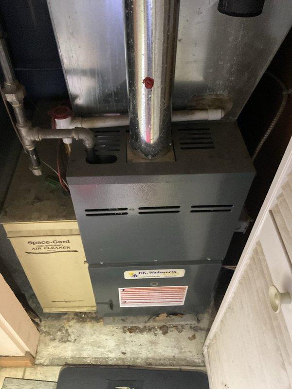 Completed routine heating maintenance on residential forced-air furnace system manufactured by P.K. Wadsworth with integrated Space-Gard air cleaner. Inspected all system components, verified proper operation of heating equipment, checked flue pipe connections, and confirmed air filtration system functionality with no deficiencies noted.