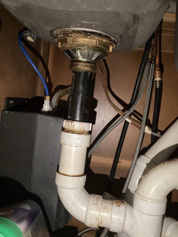 Completed comprehensive plumbing inspection of water heater installation and associated fixtures. Documented existing conditions including corroded shutoff valves, aged metal components with significant oxidation, P-trap configuration beneath water heater with staining at PVC joints, and deteriorated valve assemblies requiring future attention for proper system maintenance.