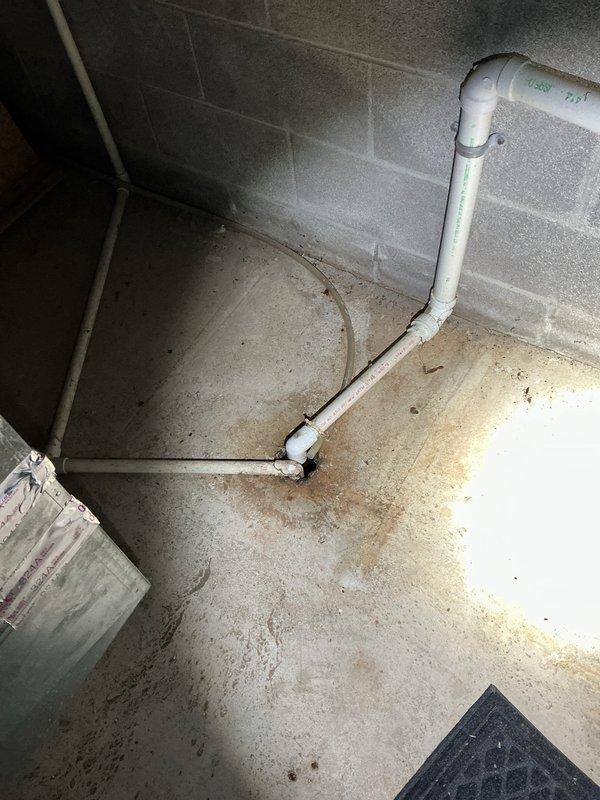 Responded to service callback for water heater installed 16 days prior that was not heating and had water pooling on floor around tank. Upon arrival, inspected tankless water heater installation and identified condensation accumulation on exterior of unit and moisture on concrete floor. Photographed conditions showing water droplets on unit casing, copper supply lines, PVC condensate drain piping, and wet floor areas. Diagnosed issue, performed necessary repairs to restore proper heating function and resolve water leakage. Verified system operation before departure.