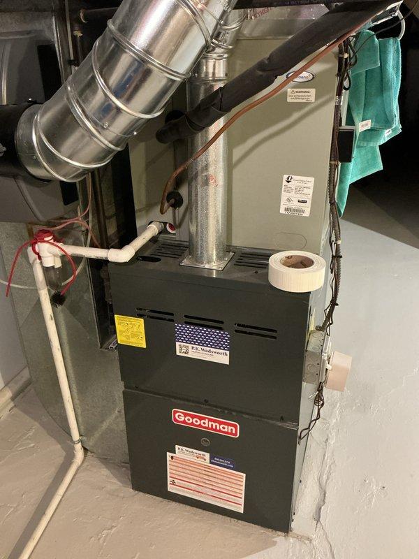 Completed scheduled heating maintenance on a Goodman brand furnace system. Performed comprehensive inspection of the unit, including examination of the heat exchanger, burner assembly, and ventilation components. Inspected and verified proper operation of the air intake filter assembly marked on the front panel, noting the white mesh filter screen was accessible and in serviceable condition. Checked all electrical connections, including visible wiring and safety controls. Examined PVC condensate drain lines and venting system for proper installation and drainage. Inspected flexible ductwork connections at the top of the unit and metal ductwork components for secure mounting and proper airflow. Verified all manufacturer labels, safety stickers, and compliance plates were intact and legible. System operational and functioning within normal parameters upon completion of maintenance procedures.
