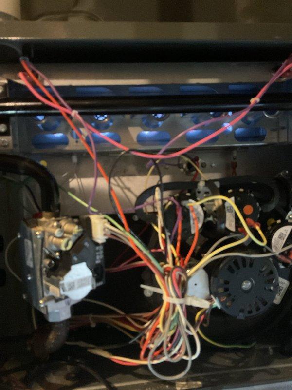 # HVAC Heating System Maintenance Completed

Performed comprehensive heating maintenance on residential HVAC air handler and furnace system. Conducted thorough inspection of all accessible components including burner assembly, gas valve, blower motor, and electrical connections. Verified proper operation of condensate drain system with PVC trap configuration. Inspected refrigerant lines with foam insulation for integrity and proper routing. Examined all electrical wiring harnesses, terminals, and control connections for secure attachment and proper color coding. Checked gas valve assembly and burner ports for proper alignment and condition. Confirmed all mechanical and electrical components operating within manufacturer specifications. System tested and left in proper working order.