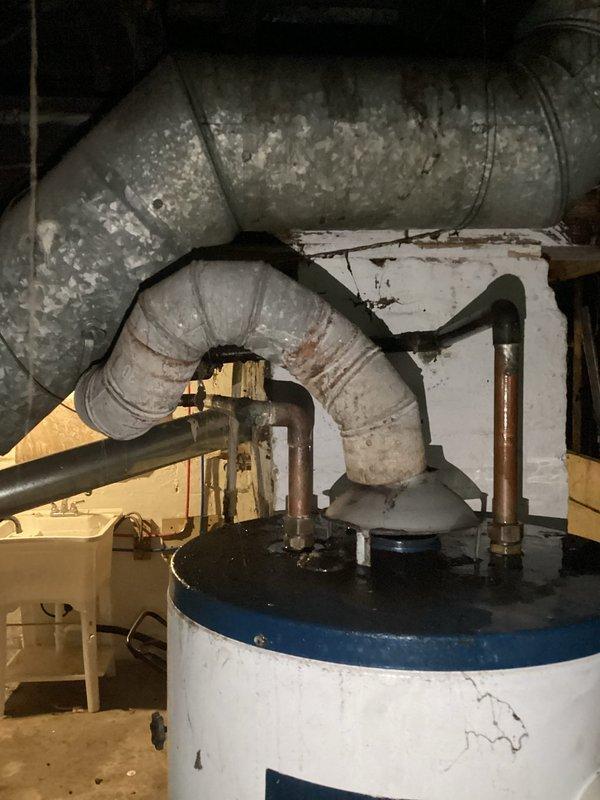 Responded to emergency call for burst water heater in basement. Removed and disposed of failed Bradford White tank-style water heater showing significant age-related deterioration including surface wear, paint cracking, and general weathering. Installed new residential tank water heater with proper copper piping connections, ensuring all plumbing connections were secure and code-compliant. Tested new unit for proper operation and verified no leaks in system.