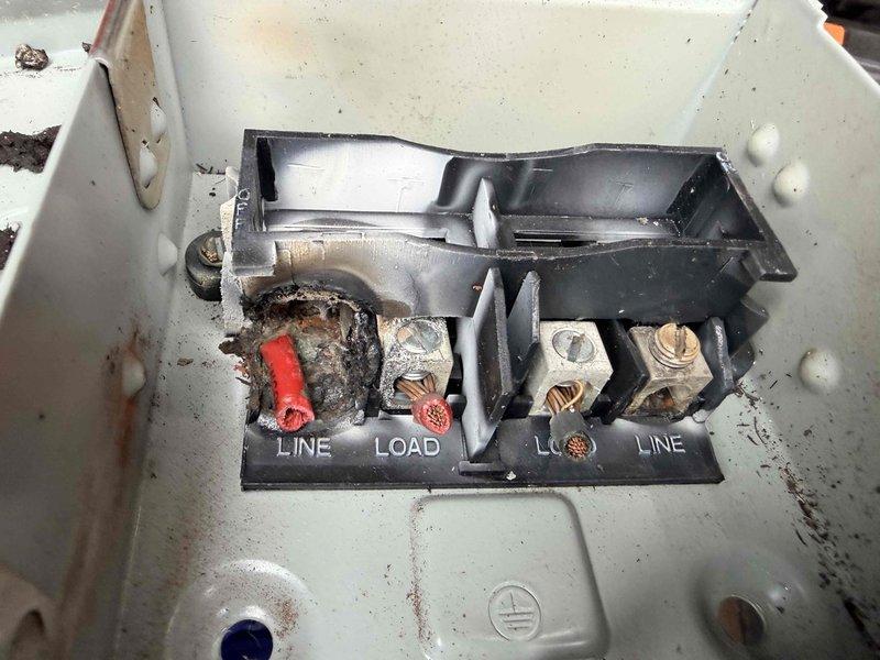 Responded to no cooling call following electrical panel repairs by third-party electrician after generator-related power surge. Upon arrival, confirmed heating operation was normal but air conditioning system would not engage at thermostat. Inspected outdoor unit disconnect and found severe heat damage to terminal block with melted plastic housing and distorted connections. Terminal block showed evidence of electrical overheating, likely caused by loose connections or compromised wiring during the electrical event that damaged the panel. Documented damaged disconnect components with photographs showing burned terminals and deteriorated wire connections. Advised customer that the AC disconnect requires immediate replacement due to safety hazard and that damaged terminals prevented proper power delivery to condensing unit, explaining why the air conditioning system would not activate despite thermostat calls for cooling.