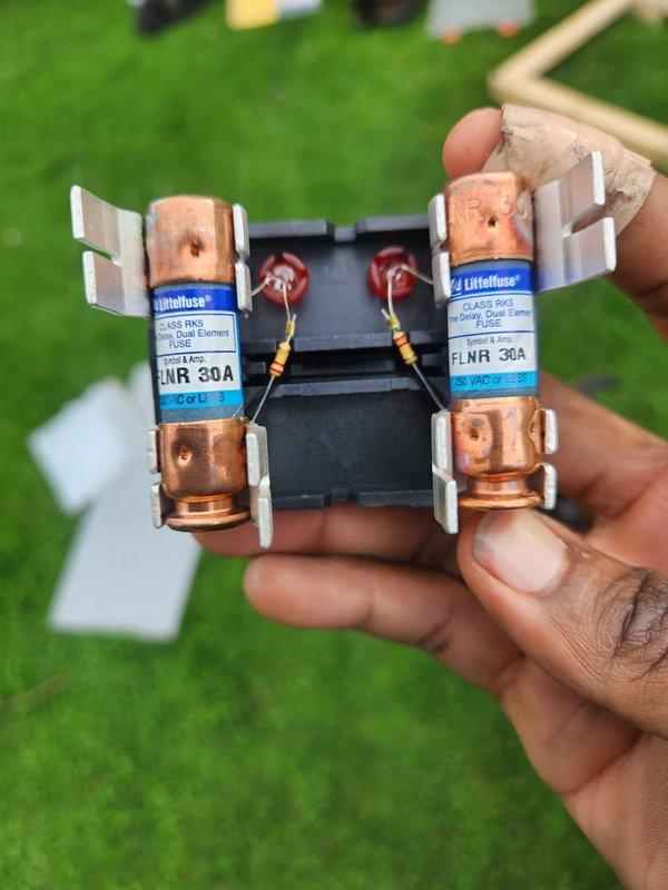 Completed full HVAC system installation including 80% efficiency furnace, air conditioning unit, and ductwork liner. Verified proper electrical connections with 30-amp FLNR fuses installed on disconnect assembly. Confirmed system operation with supply air temperature reading of 69.4°F at startup, indicating proper cooling performance and airflow distribution.