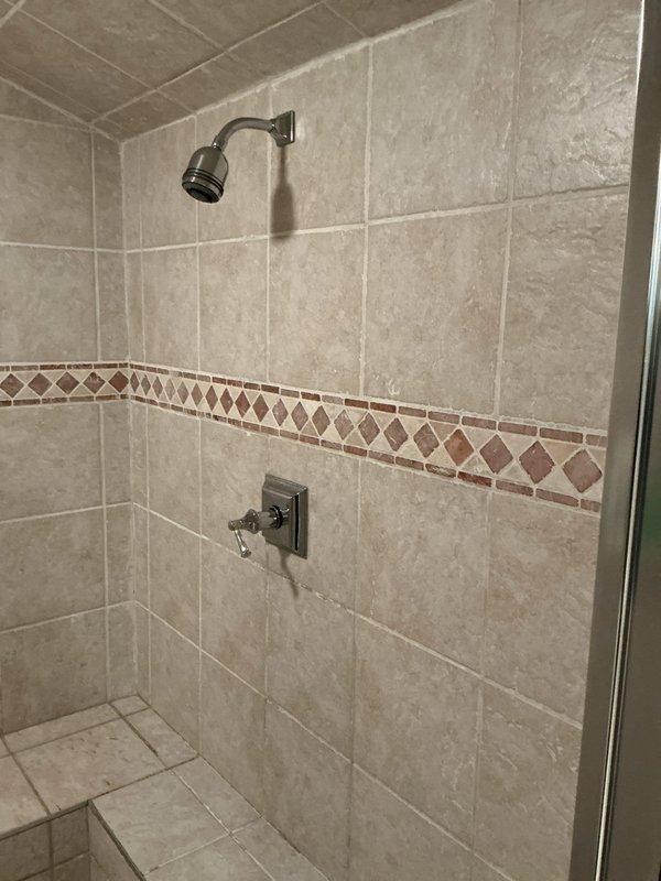 Conducted comprehensive plumbing inspection of residential property. Evaluated shower stall installation including oil-rubbed bronze fixtures, single-handle control valve, and tile work for proper installation and functionality. Inspected basement mechanical room plumbing system including copper piping configuration, three gate valves for flow control, pressure gauge assembly with capillary connection, and various brass fittings. Documented all findings with photographs for service records.