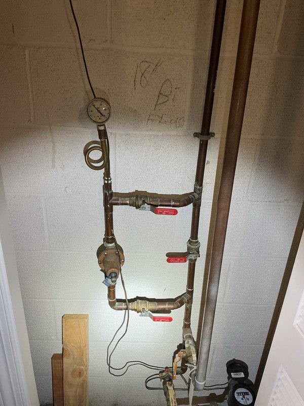 Conducted comprehensive plumbing inspection of residential property. Evaluated shower stall installation including oil-rubbed bronze fixtures, single-handle control valve, and tile work for proper installation and functionality. Inspected basement mechanical room plumbing system including copper piping configuration, three gate valves for flow control, pressure gauge assembly with capillary connection, and various brass fittings. Documented all findings with photographs for service records.