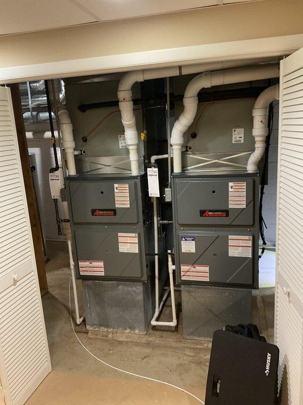 # HVAC Heating Maintenance - Dual System Service

Performed scheduled heating maintenance on two Amana furnace units installed in residential basement mechanical room. Upon inspection, discovered severe frost and ice buildup on evaporator coil of one system, indicating critical airflow restriction or refrigerant issue requiring immediate attention. Documented condition of both heating systems through photographic evidence showing the extensively frosted coil with uniform crystalline accumulation across all fins, as well as overall dual furnace installation with PVC venting configuration. The ice buildup condition suggests potential low refrigerant charge, restricted airflow due to dirty filter or blocked return, or malfunctioning blower motor requiring further diagnostic evaluation and corrective action to restore proper system operation and prevent compressor damage.