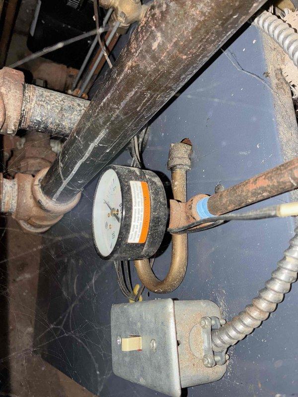 # HVAC Boiler Maintenance and Inspection

Completed comprehensive tune-up and maintenance service on boiler system over 10 years old with reported noise concerns. Upon arrival, performed thorough visual inspection revealing significant dust and debris accumulation throughout heat exchanger sections and extensive cobweb buildup on system components. Noted heavy corrosion on multiple pipe connections and gauge fittings, indicating age-related deterioration consistent with equipment age.

Cleaned heat exchanger surfaces, removing accumulated dirt and debris from metal slats and channels to restore proper heat transfer efficiency. Inspected burner assembly and combustion chamber for proper operation. Tested all safety controls including pressure gauge and electrical connections housed in junction box. Verified proper operation of flexible conduit electrical connections and confirmed secure mounting of all components.

Addressed noise complaint by examining all mechanical connections and id