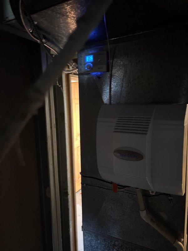 Completed full HVAC system installation including 96% efficiency furnace, air conditioning unit, and AprilAire humidifier to resolve no heat condition. Installed outdoor condenser unit on concrete pad with proper gravel base and clearances from structure. Mounted AprilAire humidifier in attic space with digital control displaying operational status. All equipment properly installed, wired, and tested for operation. System commissioned and left in working order. Whole home surge protector to be completed by electrician at later date per financing arrangement.