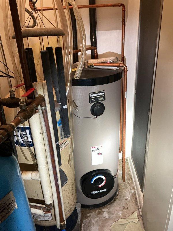 Responded to service call for reported boiler leak at residential property. Upon inspection, identified Weil-McLain Aqua Plus water heater unit with visible moisture concerns. Evaluated copper piping connections at top of unit and assessed all plumbing joints for potential leak sources. Documented equipment condition and piping configuration for service records.