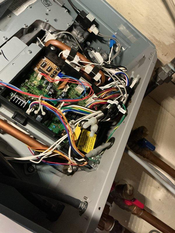 Performed comprehensive tankless water heater flush and fill maintenance service. Accessed unit's internal components, verified proper operation of isolation valves with red and blue handles, and flushed system to remove mineral buildup and sediment. Inspected circuit boards, electrical connections, and copper piping for proper function and secure mounting, confirming all components operational upon completion.