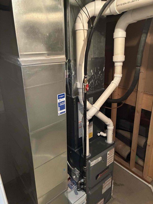 Completed full HVAC system installation including 96% efficiency furnace and air conditioning unit in residential basement utility space. Installation included proper configuration of air handler, evaporator coil, refrigerant lines with copper fittings, PVC condensate drainage system, flexible ductwork connections, and all necessary electrical components. All equipment mounted, leveled, and secured according to manufacturer specifications with proper clearances maintained for service access and code compliance.