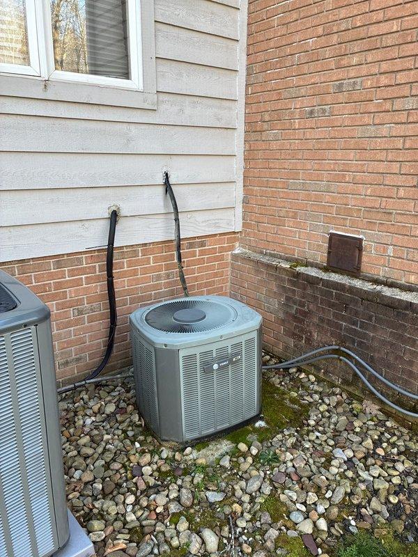 Conducted comprehensive estimate for complete HVAC system replacement due to non-functional air conditioning unit. Evaluated existing outdoor condenser units positioned on stone bed against residential exterior, assessed attic-mounted air handler and ductwork system, and documented current equipment configuration including refrigerant line routing and drainage components. Provided full system replacement options to restore cooling functionality.
