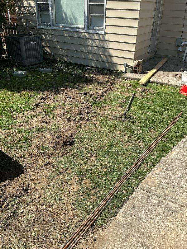Installed new 20-amp 120VAC electrical feed to garage, requiring trenching across yard to run underground conduit and wiring from main panel to garage structure. Excavation work included digging multiple trenches through lawn area, routing electrical service along exterior of building, and properly protecting all underground conductors per code requirements before backfilling and site restoration.