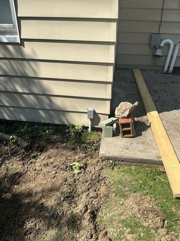 Installed new 20-amp 120VAC electrical feed to garage, requiring trenching across yard to run underground conduit and wiring from main panel to garage structure. Excavation work included digging multiple trenches through lawn area, routing electrical service along exterior of building, and properly protecting all underground conductors per code requirements before backfilling and site restoration.