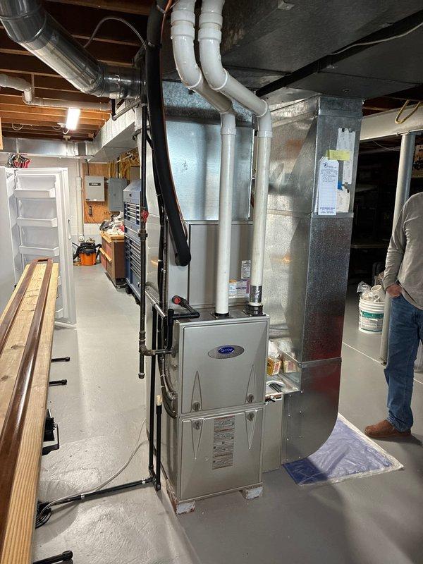 Conducted comprehensive assessment of existing Carrier furnace system experiencing operational issues. Evaluated current equipment condition, reviewed venting configuration with multiple PVC pipes, and inspected ductwork distribution system. Documented existing electrical service connection and photographed complete installation including furnace unit, air distribution network, and associated mechanical systems. Presented replacement furnace options to address ongoing performance concerns with current heating system.
