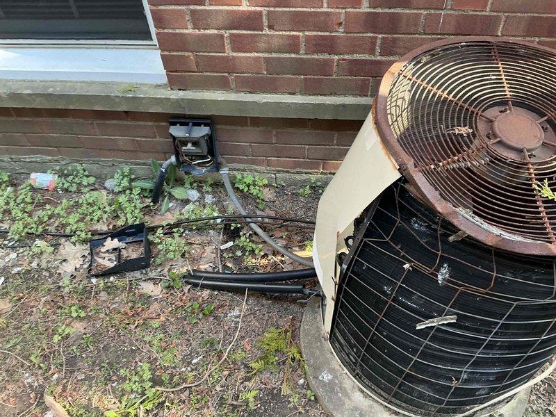 Conducted estimate for HVAC system replacement at rental property where existing outdoor condenser unit sustained damage from fallen gutter. Unit exhibited extensive rust on fan guard, weathered housing, and displaced components scattered on concrete pad, indicating compromised structural integrity and operational reliability. Assessed complete system replacement needs and provided options to property owner for new equipment installation.