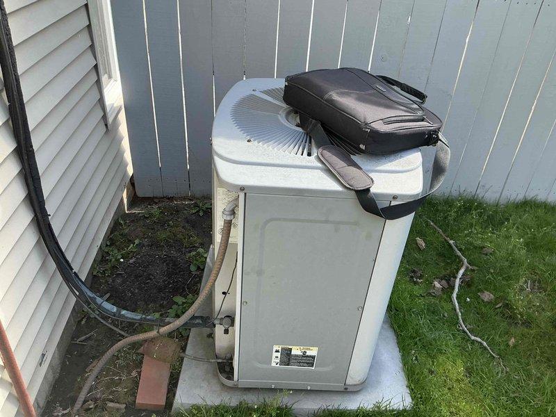 Completed full system assessment for replacement of 30-year-old HVAC system with non-functional furnace and air conditioning unit at end of service life. Documented existing indoor equipment showing significant condensation on galvanized plenum and ductwork, along with refrigerant lines and associated mechanical connections in basement installation. Evaluated outdoor condenser unit mounted on concrete pad against exterior fence, noting refrigerant line routing and overall system configuration to provide comprehensive replacement estimate for complete heating and cooling system.