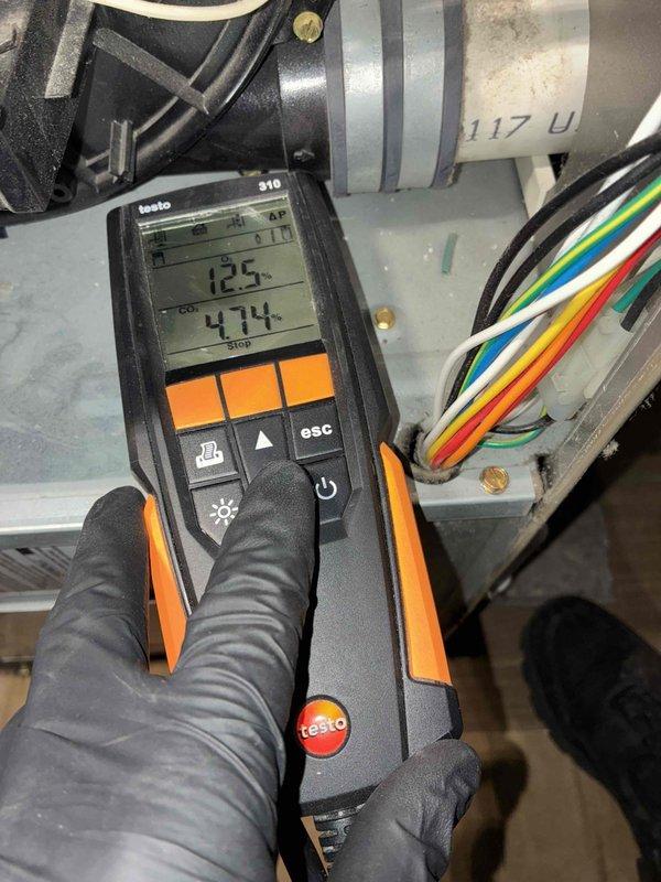 Completed scheduled heating maintenance on furnace system as part of ongoing service plan. Performed system diagnostics using calibrated digital manometer, recording pressure readings of 12.5 and 474 to verify proper airflow and system operation. Inspected blower motor assembly, electrical connections, and ductwork components. Noted normal operational wear including dust accumulation on blower motor housing and minor surface corrosion on wire retention brackets, though all wiring remained intact and properly secured with ground wire correctly installed. All system components found to be functioning within acceptable parameters with no immediate repairs required.