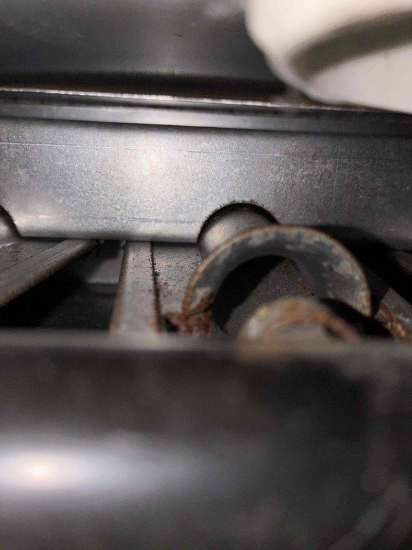 Responded to customer concern regarding possible carbon monoxide intrusion through furnace intake system. Performed comprehensive inspection of furnace intake and exhaust venting components. Upon examination, discovered significant corrosion and deterioration on exhaust vent piping and mounting hardware. Identified rust damage on curved vent connector components and observed accumulated debris around intake opening. Found compromised metal ductwork with visible wear, discoloration, and aging throughout the venting system. Documented deteriorated conditions that could potentially allow exhaust gases to enter the intake pathway. Completed heating maintenance inspection and photographed affected areas showing corroded components and compromised venting infrastructure requiring attention to ensure safe operation and proper combustion air quality.