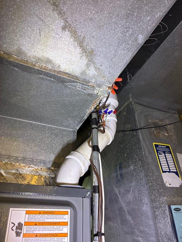 Conducted comprehensive site evaluation and documentation for HVAC system replacement in attic installation area. Assessed existing air handler unit configuration, condensate drain line routing with PVC piping and connection fittings, and sheet metal ductwork arrangement. Documented clearance measurements and structural framing dimensions to determine equipment compatibility and access requirements for replacement unit installation. Verified available workspace within confined mechanical area and photographed current system components including safety labels, insulation conditions, and drainage infrastructure to develop accurate replacement specifications and installation plan.
