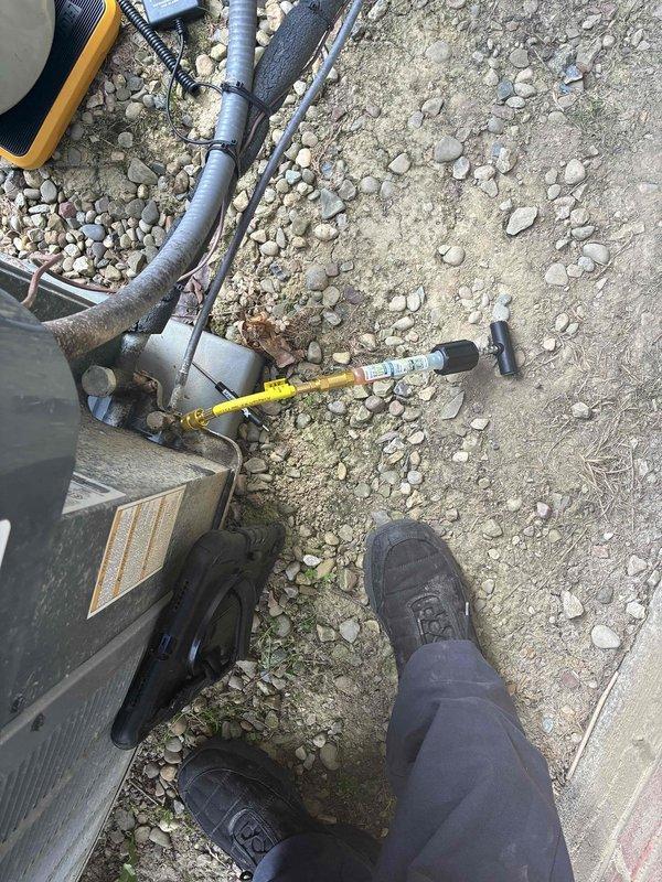 Performed refrigerant leak search using UV dye injection on residential air conditioning system. Connected manifold gauge set to service ports and introduced fluorescent dye into the refrigerant circuit to identify leak source. System will require follow-up visit to inspect for dye traces under UV light after sufficient circulation time, allowing for precise leak location identification and subsequent repair.