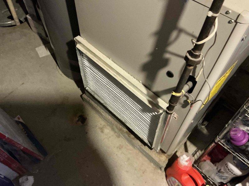 Completed HVAC system replacement estimate for air conditioning unit totaled from damage. Documented existing furnace/air handler installation in basement utility area, including evaporator coil with aluminum fins, refrigerant line routing with proper insulation and mounting, ductwork configuration, and overall system layout. Photographed current equipment condition and mechanical room setup to provide comprehensive assessment for replacement options.