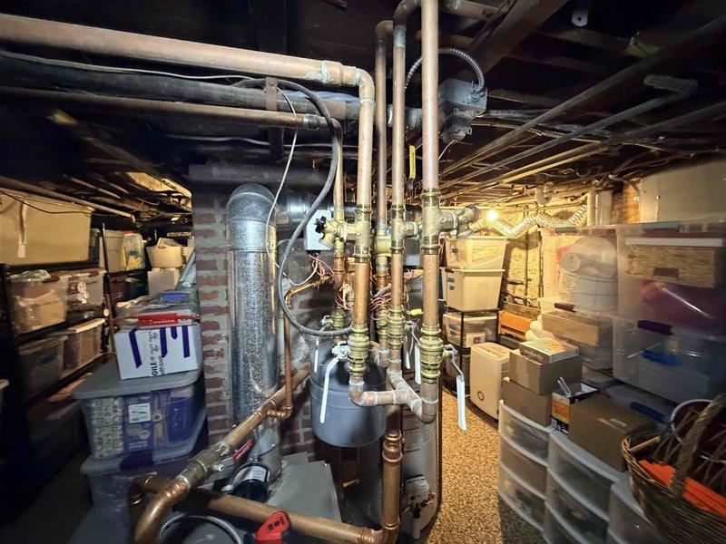 Responded to customer report of boiler leak in basement mechanical room. Upon arrival, conducted thorough visual inspection of boiler system and associated piping infrastructure. Examined copper piping assembly, brass valve connections, and fittings throughout the vertical and horizontal runs. Inspected expansion tank, pressure relief components, and all visible connection points for signs of active leaking or moisture accumulation. Documented existing conditions with photographic evidence showing complete piping configuration, valve assemblies, and mechanical equipment layout. System components including copper lines, flexible connectors, and control mechanisms were assessed for proper installation and potential failure points.