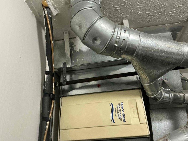 Completed comprehensive estimate for full HVAC system replacement including furnace and air conditioning unit located in first-floor utility closet. Assessed existing equipment configuration featuring Space-Gard air filtration system, galvanized metal ductwork with visible condensation, copper refrigerant lines, and beige air handler unit, documenting current installation layout and providing customer with replacement options for complete heating and cooling system upgrade.