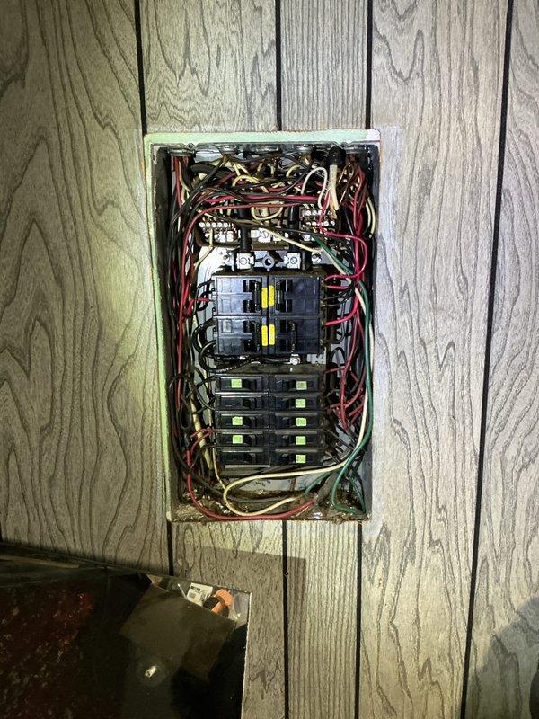 Performed comprehensive electrical panel inspection at residential property. Documented existing panel configuration showing multiple circuit breakers with visible wear indicators and disorganized wire management at service entrance. Panel exhibited bundled conductors entering from above with mixed color coding requiring attention to NEC compliance standards. Photographed interior breaker arrangement, handwritten circuit labels, and manufacturer specifications for client records and future reference.