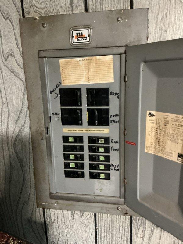 Performed comprehensive electrical panel inspection at residential property. Documented existing panel configuration showing multiple circuit breakers with visible wear indicators and disorganized wire management at service entrance. Panel exhibited bundled conductors entering from above with mixed color coding requiring attention to NEC compliance standards. Photographed interior breaker arrangement, handwritten circuit labels, and manufacturer specifications for client records and future reference.