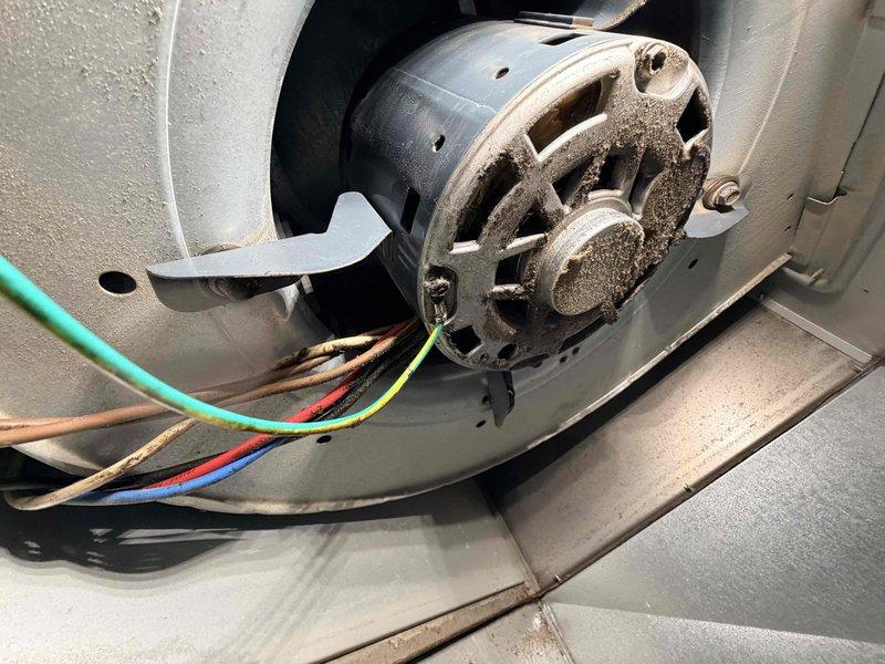 Responded to no heat call on aging furnace system. Upon inspection, identified blower motor assembly with worn electrical connections and accumulated dust buildup affecting system operation. Diagnosed motor wiring configuration, verified proper electrical connections, and assessed overall condition of blower assembly and housing components to restore heating functionality.