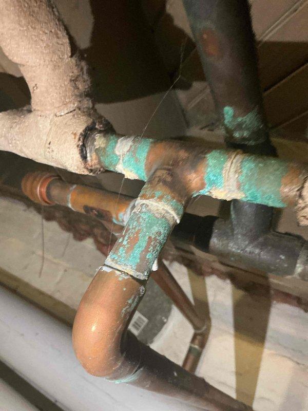 Completed scheduled preventive maintenance on water boiler heating system as part of ongoing recurring service program. Inspected boiler components, piping infrastructure, and control systems including programmable water feeder unit displaying normal operational readings. Observed significant copper pipe corrosion with green patina buildup on elbow joints and connections, documented conditions with photographs for maintenance records, and verified system operational status upon completion.