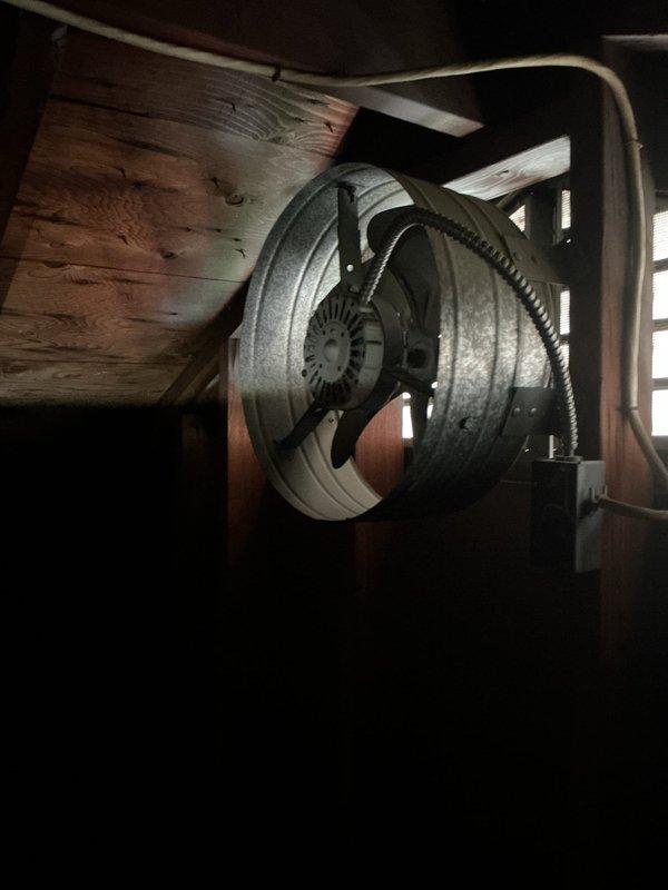 Responded to service call for non-functional attic fan that ceased operation after being turned off following previous season's wiring issue. Conducted diagnostic inspection of attic-mounted ventilation system, examining blower wheel assembly and associated electrical connections. Assessed exposed electrical outlet box with visible blue and white conductors to determine circuit integrity and switching mechanism functionality. Evaluated mounting hardware, junction box installation, and wire terminations for proper connections and code compliance. Investigated secondary concern regarding malfunctioning light switch. Documented existing conditions through photographic evidence showing blower assembly mounted to structural framing and exposed wiring at wall-mounted junction box location. Provided homeowner with repair versus replacement options for attic ventilation system restoration.