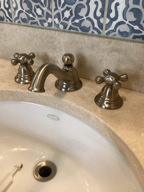 Completed plumbing inspection of residential bathroom fixtures. Identified and documented leaking toilet water supply valve requiring repair or replacement. Photographed affected areas including toilet installation and surrounding bathroom fixtures for service documentation and follow-up recommendations.
