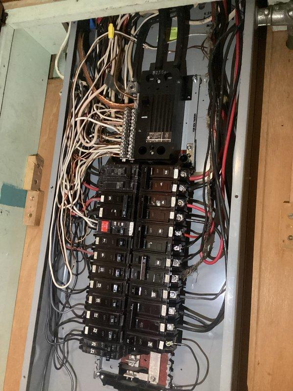Conducted comprehensive electrical assessment for panel replacement in residential garage installation. Evaluated existing electrical panel configuration with multiple circuit breakers, main disconnect, and current wire routing including service entrance conductors and branch circuit wiring. Documented panel condition, breaker arrangement, and surrounding infrastructure including overhead garage door operator system with junction box and conduit connections to provide detailed replacement specifications and material requirements for complete panel upgrade.