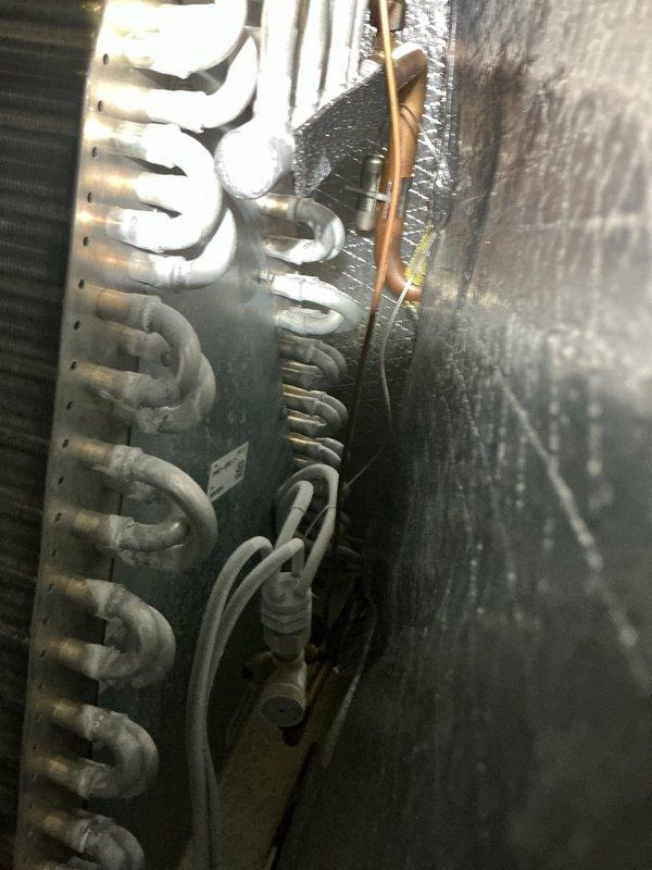 Responded to no cooling complaint on residential HVAC system. Upon arrival, performed system inspection of air handler and evaporator coil assembly. Visually examined evaporator coil for potential airflow restrictions, refrigerant leaks, or component failures. Documented equipment condition including copper refrigerant lines, aluminum fin assembly, and condensate removal system. System evaluation revealed accessible components in basement installation with PVC condensate piping and electrical connections intact. Captured diagnostic photos of air handler unit and evaporator coil for service records.