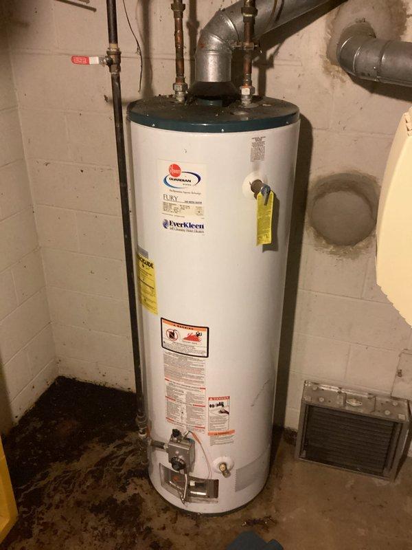 Performed on-site assessment of leaking 50-gallon gas water heater (Fury Everkleen model) installed in basement utility area. Documented existing unit condition, noting active leak evidenced by significant water staining and discoloration on concrete floor surrounding base of tank. Evaluated copper supply line connections, gas piping configuration, and venting system. Provided comprehensive estimate for replacement of failed water heater with new 50-gallon gas unit, including removal and disposal of existing equipment, installation of replacement unit to current code standards, and connection to existing plumbing and gas infrastructure.