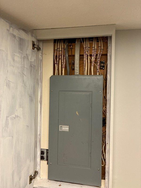 Completed comprehensive evaluation of upstairs HVAC system for full replacement options. Documented existing air handler installation showing plenum assembly with Aprilaire components, flexible ductwork connections, and associated electrical panel in utility closet. Assessed current system configuration including ductwork transitions, insulated plenum box, and copper refrigerant lines. Observed significant condensation on metallic surfaces indicating active cooling operation and temperature differential. Photographed electrical service panel, plumbing infrastructure, and complete HVAC component layout to provide detailed replacement specifications and equipment sizing recommendations for complete system upgrade.
