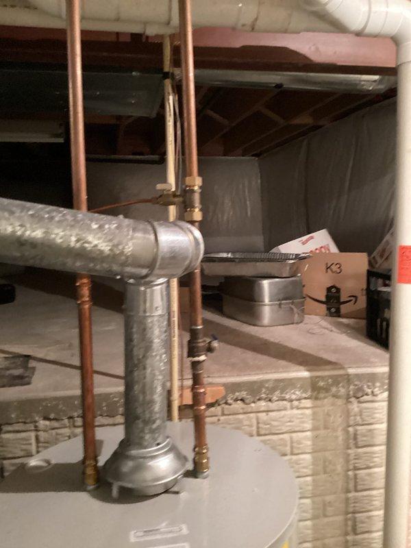 Performed routine maintenance flush on residential tanked water heater located in basement utility area. Drained sediment and mineral buildup from tank bottom through drain valve, then refilled system and verified proper operation. Inspected copper supply lines, brass fittings, and connections for leaks or corrosion—all components found in satisfactory condition. Confirmed water heater returning to normal operating temperature following flush procedure.