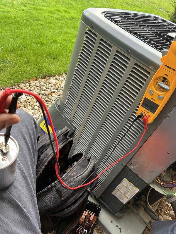 Completed comprehensive HVAC maintenance on dual heating and cooling systems, including inspection of blower wheel assembly showing normal dust accumulation and operational condition. Performed electrical diagnostics on outdoor condensing unit using multimeter to verify proper voltage and system performance, with all components functioning within manufacturer specifications.