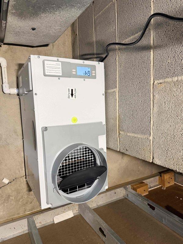 Installed Aprilaire E100 whole-home dehumidifier as a stand-alone, non-ducted unit in finished basement. Unit was positioned in suitable location outside furnace closet with dedicated 115VAC circuit run approximately 30 feet from existing Siemens electrical panel. Completed all necessary electrical connections, condensate drainage piping with PVC, and mounted unit to concrete block wall. Verified proper operation of digital control panel and tested unit functionality. Coordinated scheduling for required electrical and plumbing inspections per local code requirements.